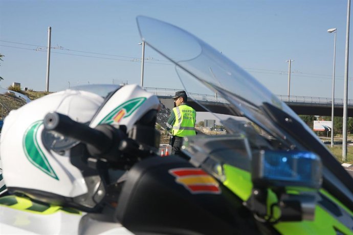 Archivo - Una moto, un casco y un agente de la  Guardia Civil de Tráfico