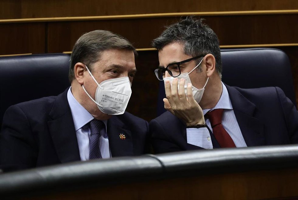 El ministro de Agricultura, Pesca y Alimentación, Luis Plana (i), y el ministro de la Presidencia, Relaciones con las Cortes y Memoria Democrática, Félix Bolaños, conversan en una sesión plenaria en el Congreso