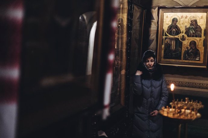Una dona se senya en una església de Kíiv (Ucrana)