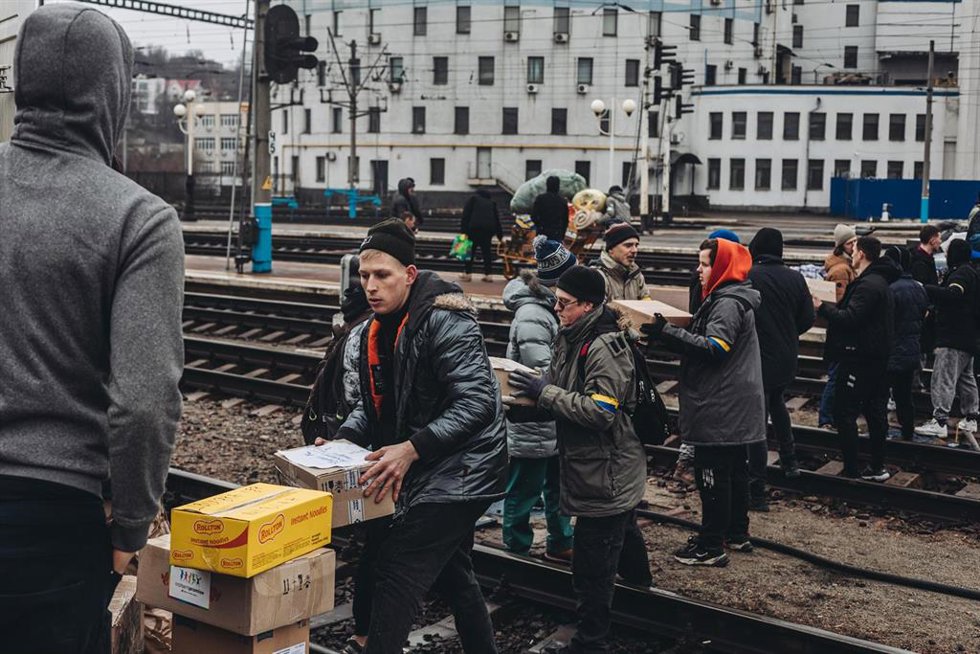 Varios jóvenes cargan provisiones para la ciudad de Kiev ante la posible llegada de las tropas rusas.