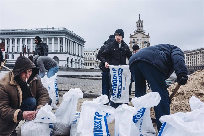 Varias personas llenan sacos de arena para construir barricadas en la plaza de Maidan