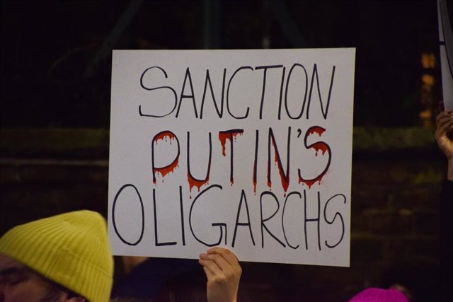 Un Manifestante Sostiene Una Pancarta "Sancionar A Los Oligarcas De Putin". Manifestantes Reunidos Frente A La Embajada Rusa En Londres En Protesta Por La Invasión Rusa De Ucrania.