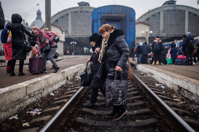 Dos mujeres cruzan las vías a 4 de marzo de 2022, en la estación de tren de Leópolis (Ucrania). 