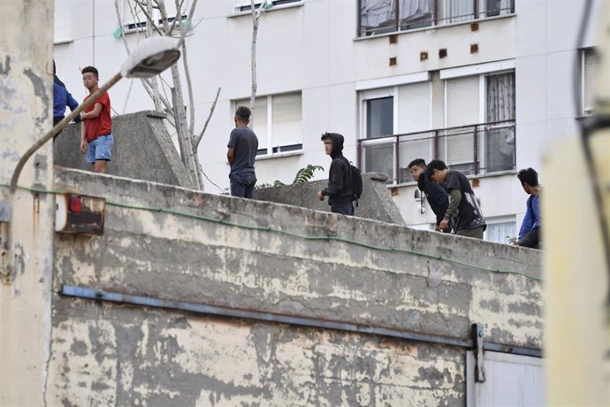 Archivo - Varios menores migrantes, en el tejado de una nave industrial en Ceuta, en una imagen de archivo.