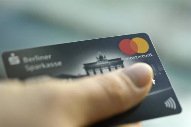 Archivo - Una persona sostiene una tarjeta de crédito de Mastercard. 