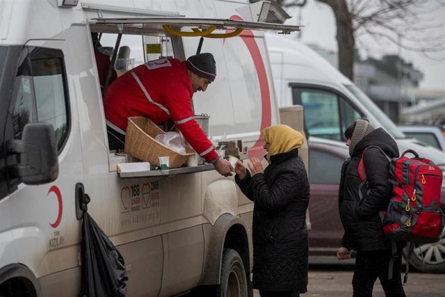 Una  mujer recibe una bebida caliente de la Cruz Roja turca, en el paso fronterizo de Porubne, a 5 de marzo de 2022, en el oeste de Ucrania. 