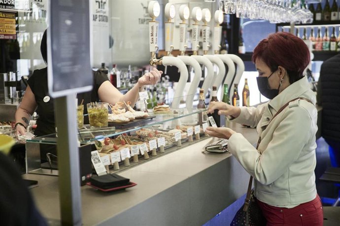 Archivo - Una mujer paga su consumición en el interior de un bar, a 1 de octubre de 2021, en Pamplona, Navarra (España)