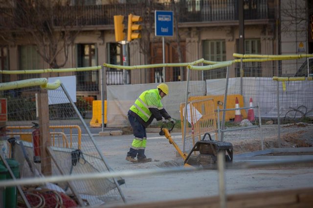 Un obrero en la  Diagonal con Paseo de Sant Joan, una de las vías afectadas por las obras para conectar el tranvía