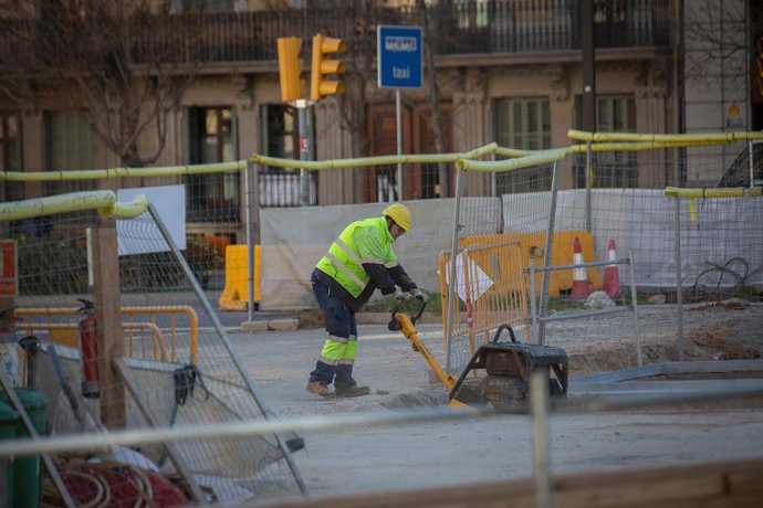 Un obrer en  la Diagonal amb Passeig de Sant Joan, una de les vies afectades per les obres per connectar el tramvia