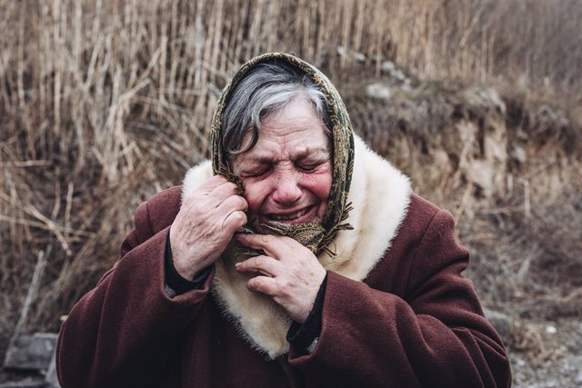 Una dona plora quan sent els bombardeigs