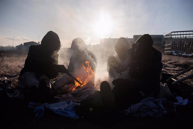 Un grupo de personas ghanesas preparan una hoguera en Medyka, frontera de Polonia con Ucrania