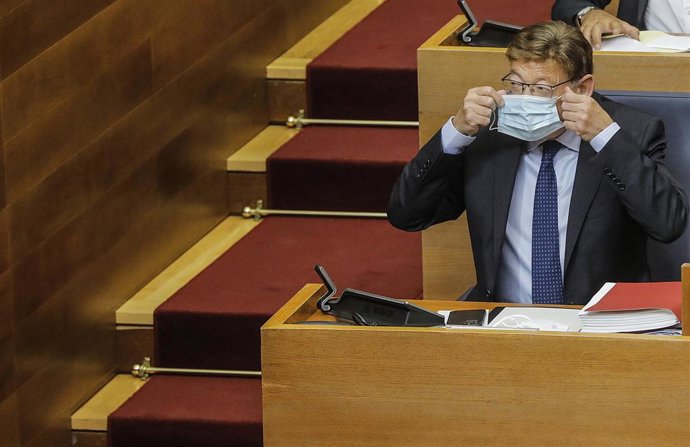 Archivo - El 'president' de la Generalitat, Ximo Puig, se coloca la mascarilla durante un pleno de Les Corts