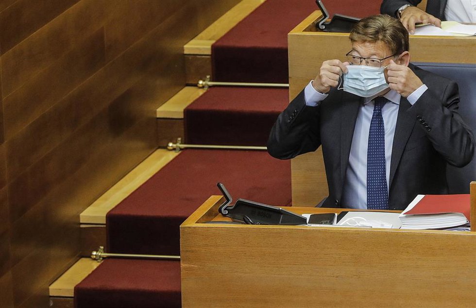 Archivo - El 'president' de la Generalitat, Ximo Puig, se coloca la mascarilla durante un pleno de Les Corts