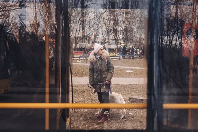 Una mujer y su perro a las puertas de un autobús de evacuación, a 7 de marzo de 2022, en Kiev (Ucrania). El ejército de Ucrania resiste por el momento el duro asedio de Rusia en algunas de sus ciudades, como Irpin y Kiev, donde se recrudecen los combates.