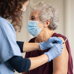 Archivo - Una mujer se vacuna contra el COVID