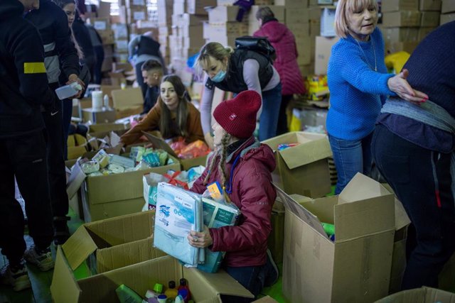 Varias voluntarios organizan las cajas de ayuda humanitaria en un pabellón cerca de la frontera entre Polonia y Ucrania
