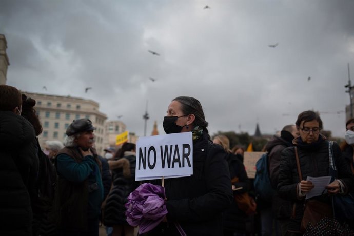 Una persona sostiene una pancarta durante una concentración para reclamar el alto al fuego y la retirada de las tropas rusas de Ucrania, en la plaza Cataluña, a 2 de marzo de 2022, en Barcelona, Cataluña (España). Esta movilización, que se suma a las qu
