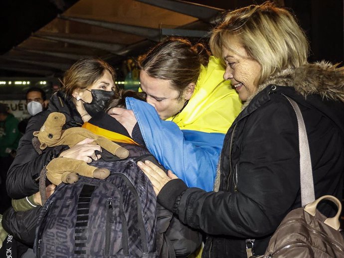 Varias personas se abrazan a su llegada a Valencia tras haber finalizado un viaje en autobús a bordo de la ONG Juntos por la Paz para escapar de Ucrania