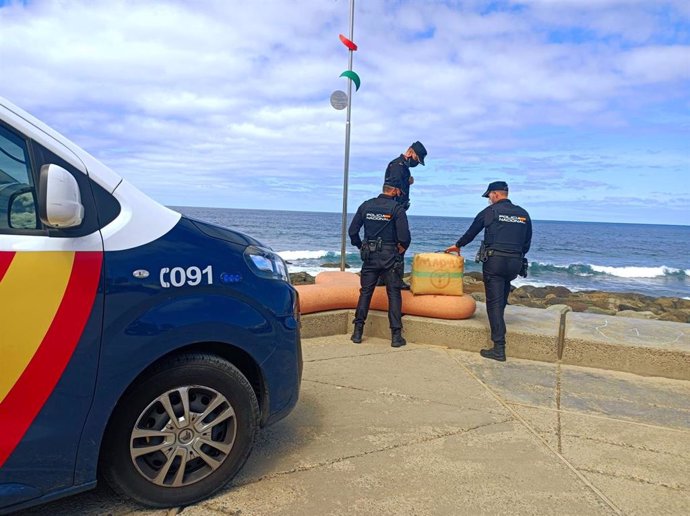 Agentes de la Policía Nacional incautando el segundo fardo de droga que ha llegado a la playa de Las Canteras, en Las Palmas de Gran Canaria