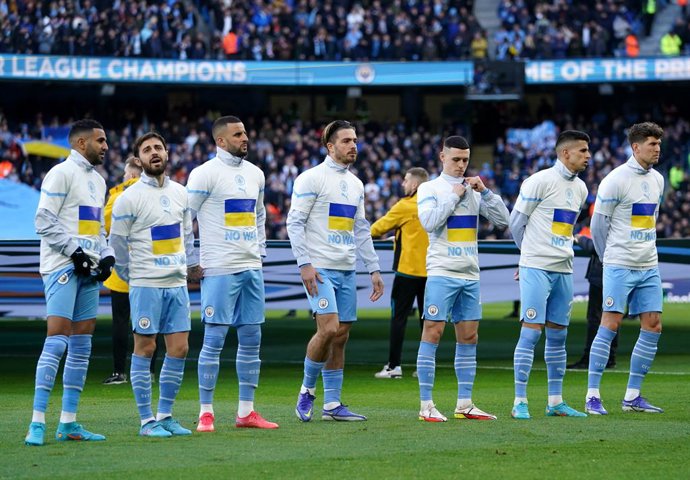 06 March 2022, United Kingdom, Manchester: Manchester City players wear t shirts with Ukraine flags in solidarity prior to the start of the English Premier League soccer match between Manchester City and Manchester United at the Etihad Stadium. Photo: M