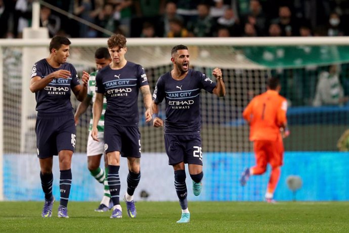 15 February 2022, Portugal, Lisbon: Manchester City's Riyad Mahrez (R) celebrates scoring his side's first goal with team-mates during the UEFA Champions League Round of 16 1st Leg soocer match between Sporting Lisbon and Manchester City at the Jose Alv