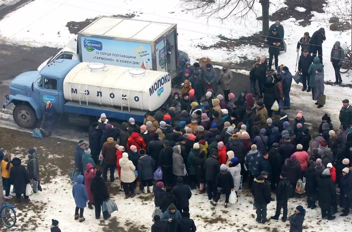 08 March 2022, Ukraine, Lubny: People stand in lines for dairy products by the Harmony farm which are distributed to low-income people, pensioners, multi-children families and IDPs from places of military hostilities, in Lubny, Poltava Region, east-cent