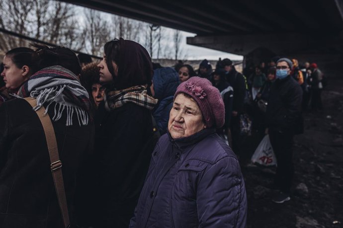 Una mujer mayor, junto a otras personas, espera para cruzar el  río de Irpin, a 5 de marzo de 2022, en Irpin (Ucrania). El ejército de Ucrania resiste por el momento el duro asedio de Rusia a su capital, Kiev, donde se recrudecen los combates. Naciones 