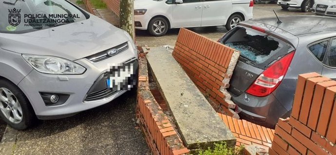 Circula sin carné en Pamplona y choca contra un muro que cae sobre un vehículo estacionado.
