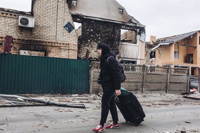 Una persona camina frente a una casa destruida por el bombardeo, a 5 de marzo de 2022, en Irpin (Ucrania)
