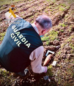 Un guardia civil manipula una granada de mortero encontrada en Zarza Capilla