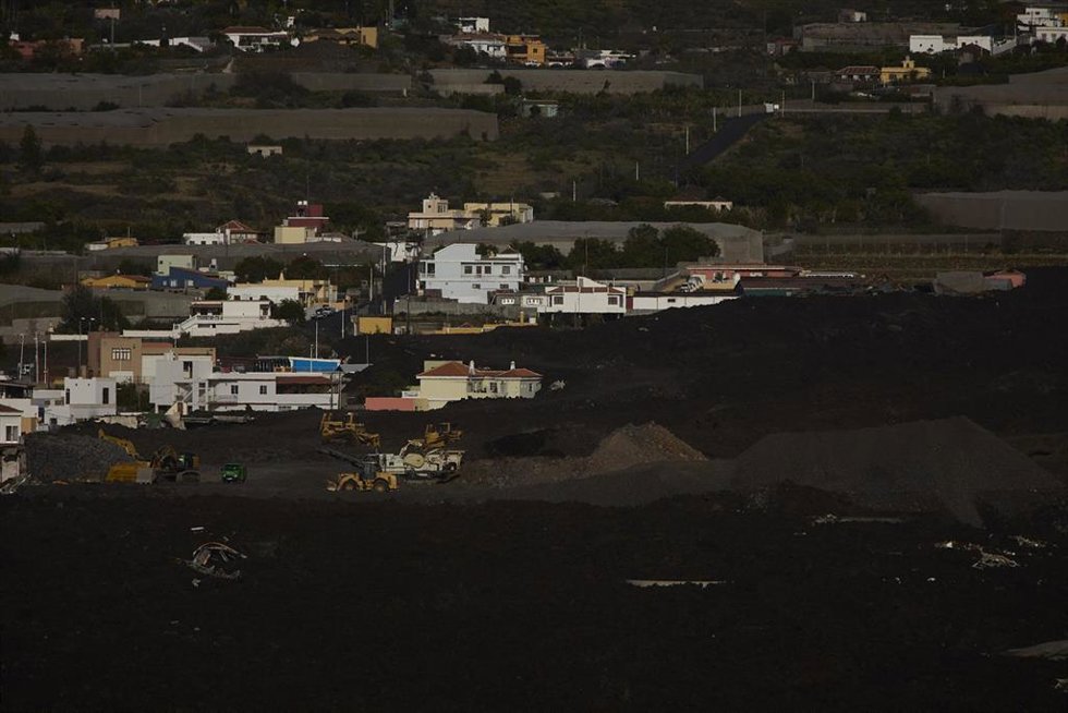 Varias viviendas entre las coladas resultantes de la erupción volcánica de Cumbre Vieja, desde la montaña La Laguna