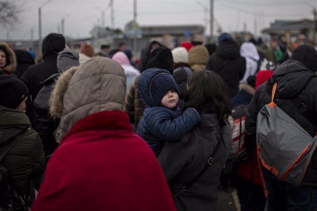 Varias personas y niños, esperan para cruzar a Rumanía, en el paso fronterizo de Porubne, a 5 de marzo de 2022, en el oeste de Ucrania. 