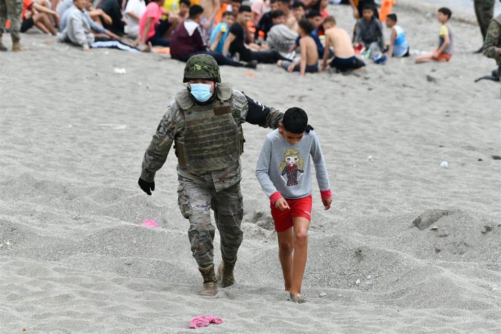 Archivo - Un militar del ejército español acompaña a un niño en una jornada marcada por las devoluciones en caliente que están efectuando a los migrantes que han entrado en Ceuta procedente de Marruecos, a 18 de mayo de 2021, en Ceuta