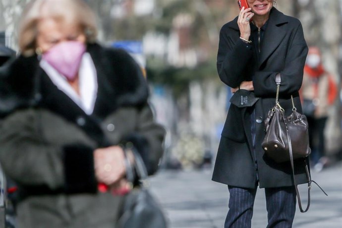 Una mujer habla por teléfono sin mascarilla.