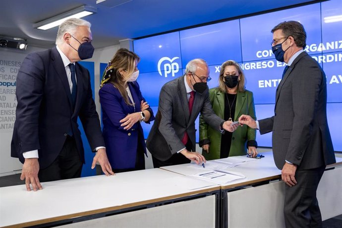 El presidente de la Xunta de Galicia, Alberto Núñez Feijóo (d), firma la entrega de los avales necesarios para formalizar su candidatura en la sede nacional del PP, en la calle Génova, a 9 de marzo de 2022, en Madrid (España). 