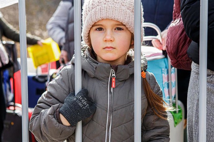 08 March 2022, Ukraine, ---: A girl looks through the bars at the Uzhhorod-Vysne Nemecke checkpoint on the Ukraine-Slovakia border as people are forced to flee due to the Russian invasion. Photo: -/Ukrinform/dpa