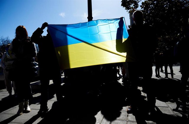 Varias personas con una bandera de Ucrania se manifiestan contra la guerra en Santander