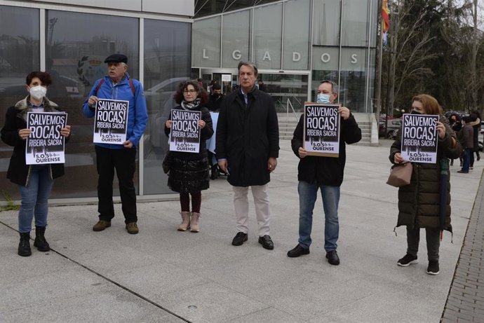 Un grupo de personas participa en una concentración contra las obras en San Pedro de Rocas al considerar que causarán graves daños en un entorno protegido, a las puertas de los Juzgados de Ourense donde se iba a celebrar un juicio que finalmente ha si