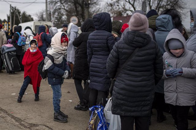 Varias personas y niños, esperan para cruzar a Rumanía, en el paso fronterizo de Porubne, a 5 de marzo de 2022, en el oeste de Ucrania. 