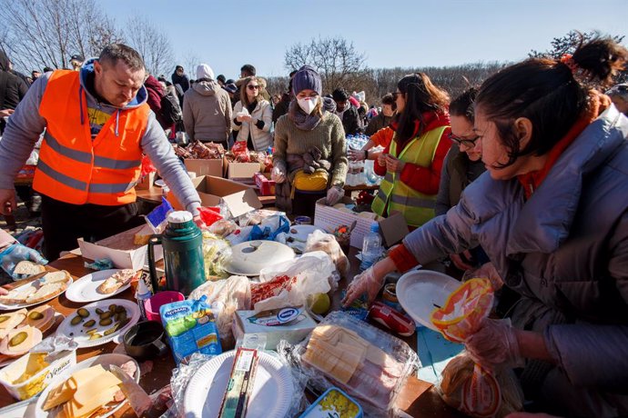 27 February 2022, Ukraine, Uzhhorod: Refugees are offered food at the Ukrainian-Slovak border. According to the UN Refugee Agency (UNHCR), about 368,000 people are on the run because of the Russian attack on Ukraine. Photo: -/Ukrinform/dpa