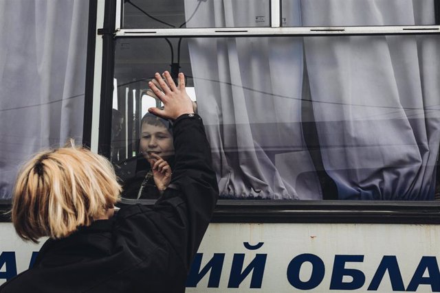 Un joven despide a un amigo desde fuera del autobús, a 24 de febrero de 2022, en Lisichansk, Oblast de Lugansk ( Ucrania). Tras el ataque de Rusia hacia Ucrania, miles de personas han huido del Donbass, región al este del país.