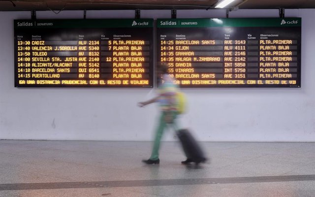 Archivo - Una mujer camina por un pasillo de la estación de Atocha para coger un AVE