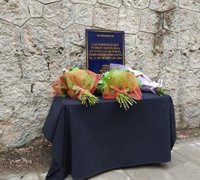 Una placa rodeada de flores pide justicia y paz para las víctimas del 11M en la calle Téllez