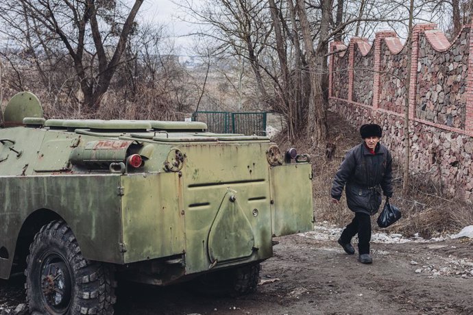 Un home al costat d'un vehicle blindat a Ucrana