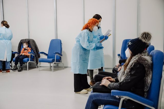 Dos sanitarios con los posibles refugiados ucranianos en una sala donde esperan los resultados de la PCR, después de llegar en un autobús desde Polonia, en el Zendal