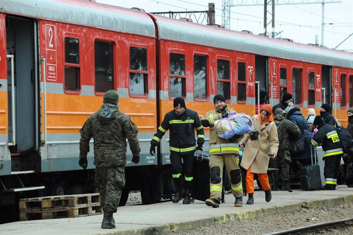 11 March 2022, Poland, Medyka: Rescue workers help a migrant board a train in the small village of Medyka. The Russian invasion of Ukraine triggered the largest mass migration to Europe in decades, with more than 1.5 million people, most of whom came th