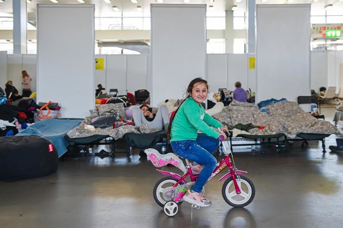 Una niña refugidada de Ucrania juega con una bicicleta en el Pabellón B de la Exposición de Brno