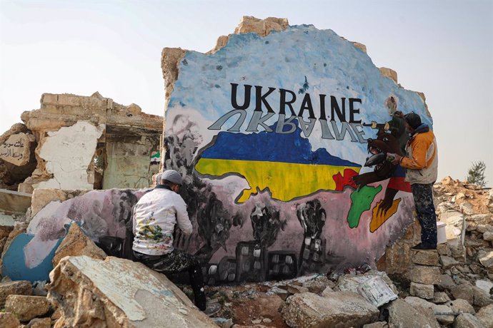 24 February 2022, Syria, Binnish: Syrian painters draw a mural in solidarity with Ukraine on a wall of a destroyed home in the wake of the Russian invasion of Ukraine. Photo: Anas Alkharboutli/dpa