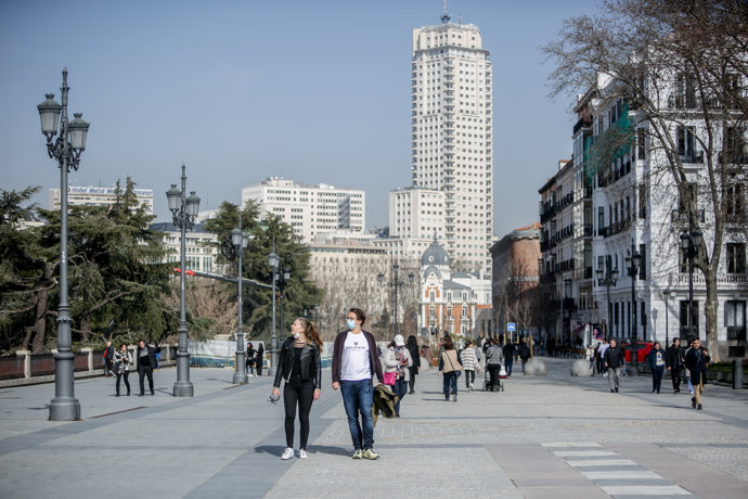 Una mujer camina sin mascarilla y un hombre con mascarilla, a 10 de febrero de 2022, en Madrid (España). 