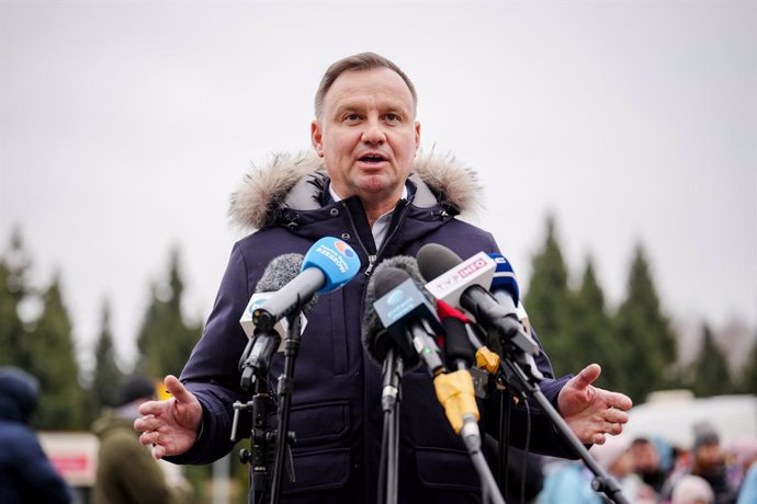 04 March 2022, Poland, Korczowa: President of the Republic of Poland Andrzej Duda (C) speaks to media representatives as he visits the Ukrainian-Polish border at the Korczowa border crossing. Numerous people arrive every day, fleeing the war in Ukraine.